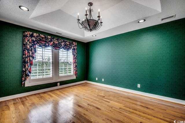 1473 Basin Trl, Murrells Inlet, SC 29576 - spare room featuring a chandelier, wood finished floors, a textured ceiling, wallpapered walls, and a tray ceiling