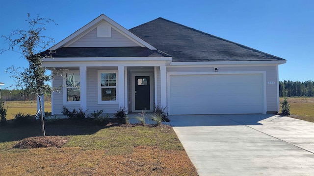 141 Dagger Ct, Myrtle Beach, SC 29588 - view of front facade with a shingled roof, an attached garage, a front yard, concrete driveway, and covered porch