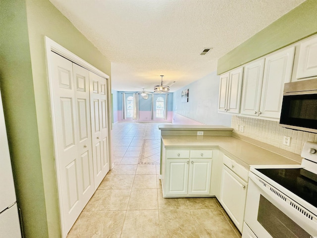 3978 Tybre Downs Cir Unit 3978, Little River, SC 29566 - kitchen with electric stove, stainless steel microwave, a peninsula, light tile patterned floors, and a chandelier