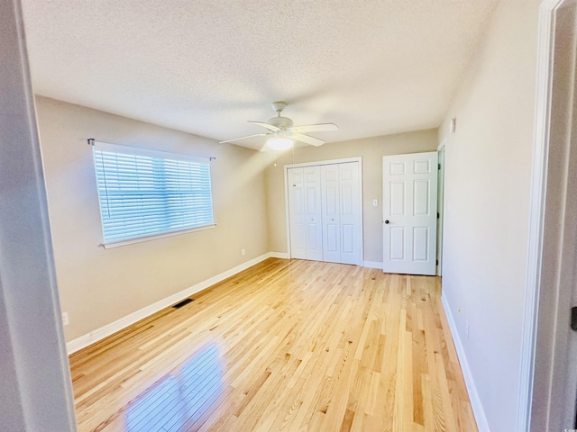 3978 Tybre Downs Cir Unit 3978, Little River, SC 29566 - unfurnished bedroom with light wood-style flooring, a closet, a textured ceiling, and a ceiling fan