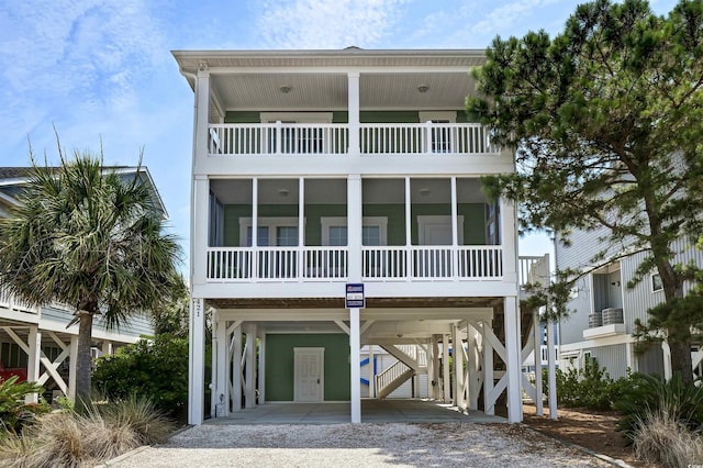 421 30th Ave S, Sunset Beach, NC 28468 - beach home with a carport, driveway, a balcony, and a sunroom