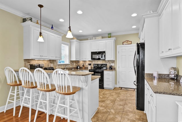 421 30th Ave S, Sunset Beach, NC 28468 - kitchen featuring black appliances, a breakfast bar, white cabinetry, ornamental molding, and decorative backsplash