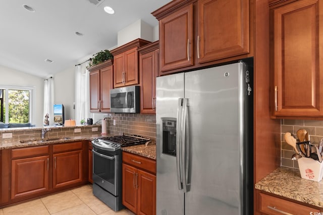 637 Grand Cypress Way, Murrells Inlet, SC 29576 - kitchen with appliances with stainless steel finishes, backsplash, vaulted ceiling, light stone countertops, and brown cabinets