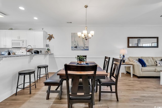 4821 Luster Leaf Cir Unit 202, Myrtle Beach, SC 29577 - dining room featuring ornamental molding, a chandelier, light wood-style flooring, and recessed lighting