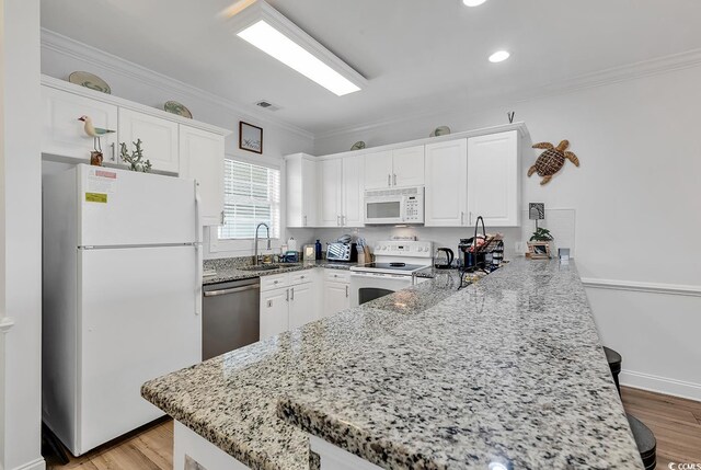 4821 Luster Leaf Cir Unit 202, Myrtle Beach, SC 29577 - kitchen with white appliances, a peninsula, crown molding, white cabinetry, and recessed lighting