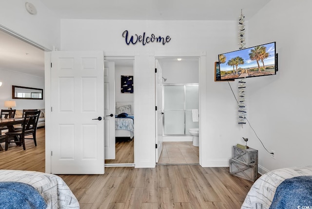 4821 Luster Leaf Cir Unit 202, Myrtle Beach, SC 29577 - bedroom with light wood-type flooring and connected bathroom