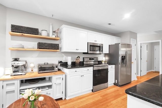 174 Edward Ave, Murrells Inlet, SC 29576 - kitchen with appliances with stainless steel finishes, open shelves, white cabinetry, and light wood-style floors