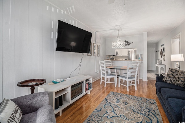 9501 Shore Dr Unit 135, Myrtle Beach, SC 29572 - living room with a chandelier, light wood-style flooring, and a textured ceiling