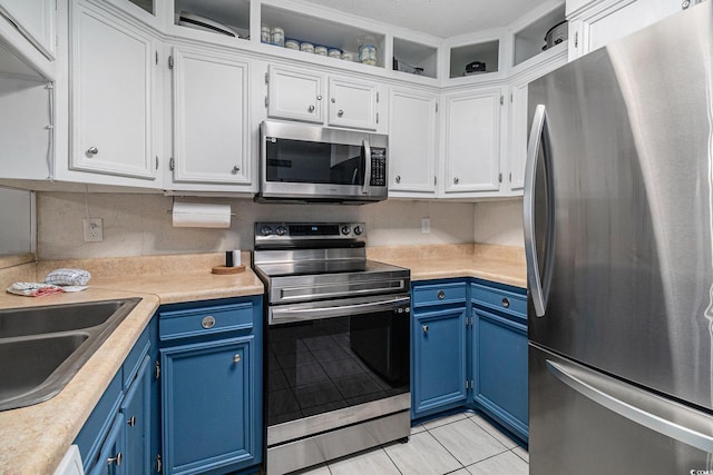 9501 Shore Dr Unit 135, Myrtle Beach, SC 29572 - kitchen featuring stainless steel appliances, blue cabinets, light tile patterned floors, and light countertops