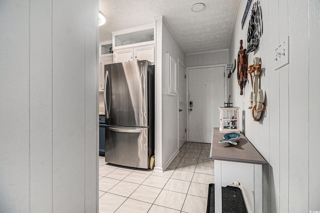 9501 Shore Dr Unit 135, Myrtle Beach, SC 29572 - kitchen featuring freestanding refrigerator, light tile patterned floors, a textured ceiling, dark countertops, and white cabinetry
