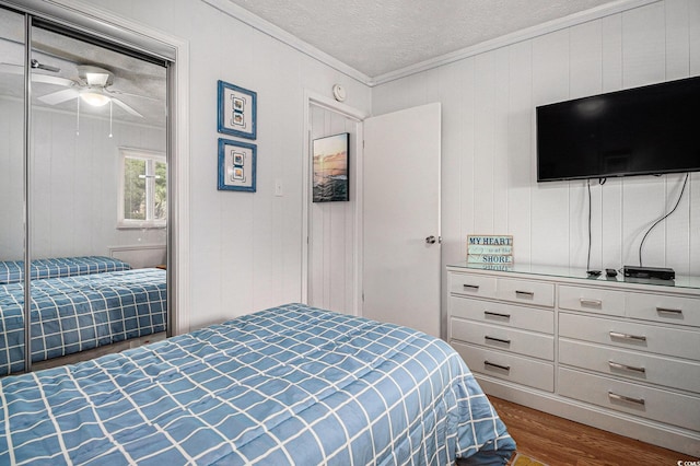 9501 Shore Dr Unit 135, Myrtle Beach, SC 29572 - bedroom with wood finished floors, ornamental molding, a textured ceiling, and a ceiling fan