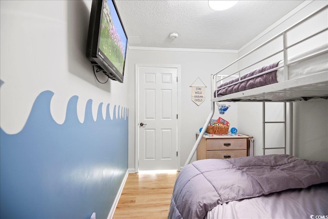 9400 Shore Dr Unit 409, Myrtle Beach, SC 29572 - bedroom with light wood-style flooring, a textured ceiling, and ornamental molding