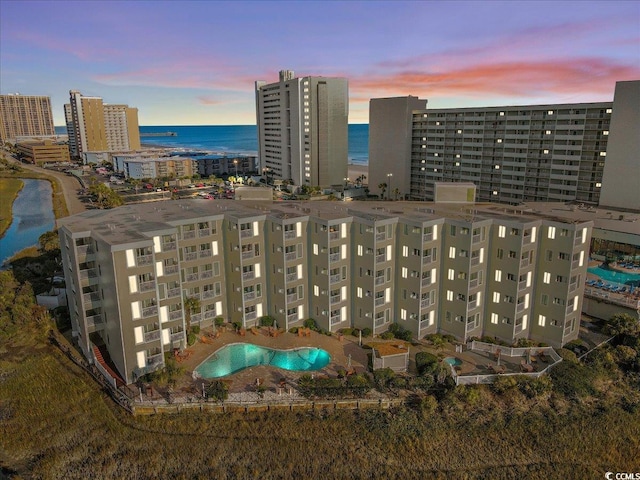 9400 Shore Dr Unit 409, Myrtle Beach, SC 29572 - aerial view at dusk of a water view, view of pool area, and a view of apartment building / complex
