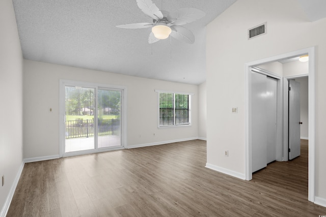 6576 Pebble Beach Cres, Myrtle Beach, SC 29588 - empty room with wood finished floors, a ceiling fan, high vaulted ceiling, and a textured ceiling