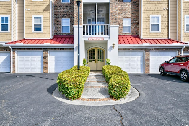 5650 Barefoot Resort Bridge Rd Unit 431, North Myrtle Beach, SC 29582 - view of front of home featuring a standing seam roof, brick siding, driveway, an attached garage, and french doors