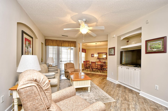 5650 Barefoot Resort Bridge Rd Unit 431, North Myrtle Beach, SC 29582 - living area featuring a textured ceiling, a ceiling fan, light wood-type flooring, and built in shelves