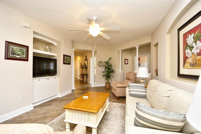 5650 Barefoot Resort Bridge Rd Unit 431, North Myrtle Beach, SC 29582 - living room with a ceiling fan, decorative columns, a textured ceiling, light wood-type flooring, and built in shelves