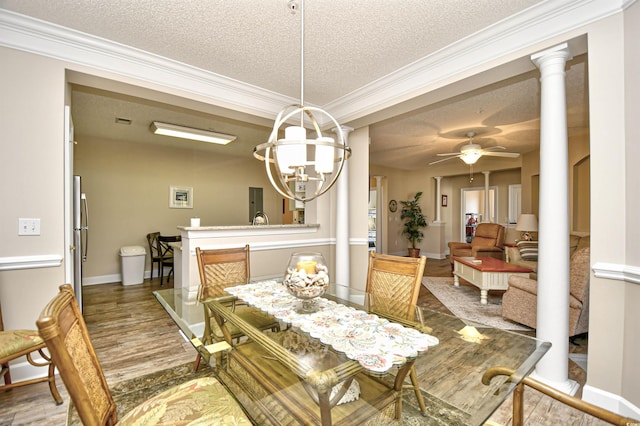 5650 Barefoot Resort Bridge Rd Unit 431, North Myrtle Beach, SC 29582 - dining room featuring a textured ceiling, crown molding, wood finished floors, a chandelier, and ornate columns