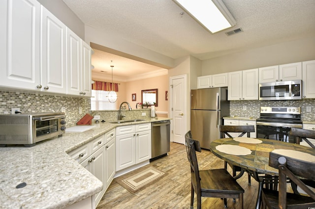5650 Barefoot Resort Bridge Rd Unit 431, North Myrtle Beach, SC 29582 - kitchen with appliances with stainless steel finishes, light wood finished floors, white cabinetry, decorative backsplash, and crown molding