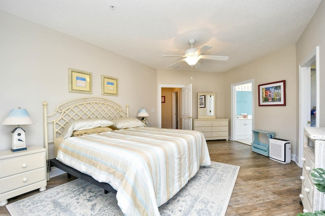 5650 Barefoot Resort Bridge Rd Unit 431, North Myrtle Beach, SC 29582 - bedroom featuring wood finished floors, connected bathroom, a ceiling fan, and a textured ceiling
