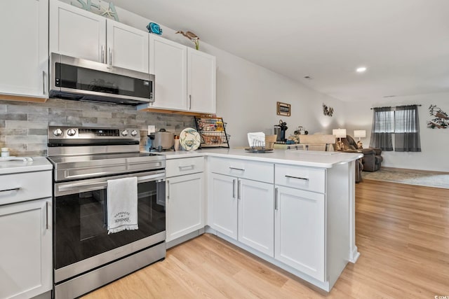 775 Plantation Dr Unit 53, Little River, SC 29566 - kitchen with appliances with stainless steel finishes, a peninsula, light wood-style floors, open floor plan, and backsplash