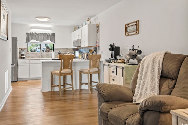 775 Plantation Dr Unit 53, Little River, SC 29566 - kitchen with open floor plan, stainless steel microwave, tasteful backsplash, and a peninsula