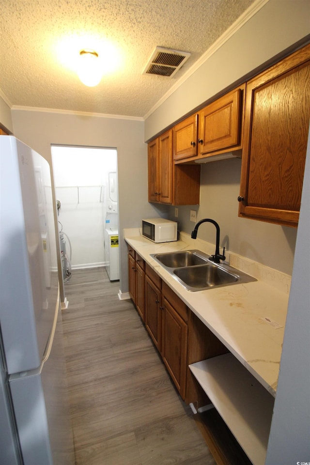 950 Forestbrook Rd Unit B-8, Myrtle Beach, SC 29588 - kitchen featuring white appliances, a textured ceiling, light countertops, brown cabinets, and crown molding