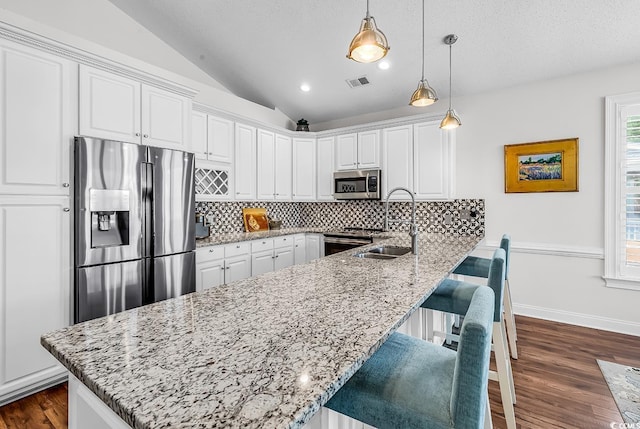 5 Tiara Ln, Murrells Inlet, SC 29576 - kitchen with appliances with stainless steel finishes, tasteful backsplash, white cabinets, vaulted ceiling, and recessed lighting