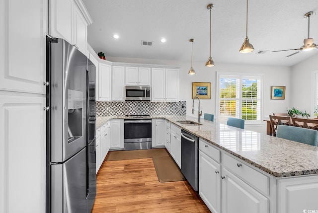 5 Tiara Ln, Murrells Inlet, SC 29576 - kitchen featuring stainless steel appliances, a peninsula, white cabinetry, tasteful backsplash, and recessed lighting