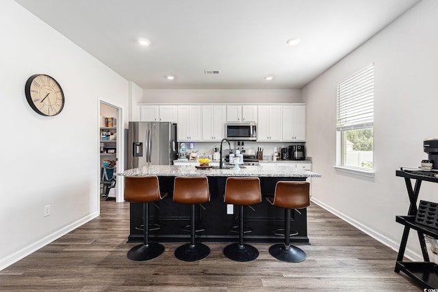 651 Choctaw Dr, Conway, SC 29526 - kitchen featuring appliances with stainless steel finishes, an island with sink, white cabinets, a kitchen bar, and recessed lighting