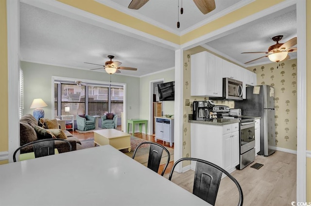 6001-1459 S Kings Hwy, Myrtle Beach, SC 29575 - kitchen with stainless steel appliances, a ceiling fan, ornamental molding, open floor plan, and white cabinets