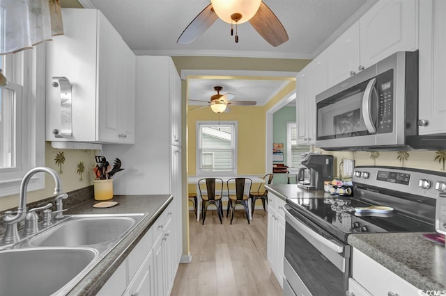 6001-1459 S Kings Hwy, Myrtle Beach, SC 29575 - kitchen with stainless steel appliances, a ceiling fan, light wood-style floors, white cabinetry, and ornamental molding