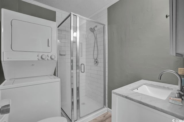 6001-1459 S Kings Hwy, Myrtle Beach, SC 29575 - bathroom featuring stacked washer / drying machine, a stall shower, vanity, a textured ceiling, and wood finished floors