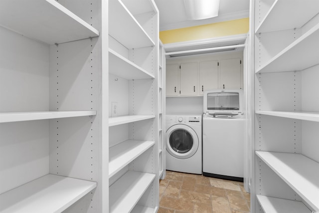 571 Fernwood Rd, Murrells Inlet, SC 29576 - laundry area featuring washer / clothes dryer, cabinet space, and light stone finish floors