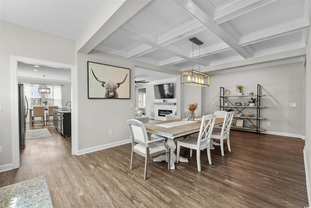 264 Switchgrass Loop, Little River, SC 29566 - dining area featuring a chandelier, wood finished floors, beam ceiling, a glass covered fireplace, and crown molding