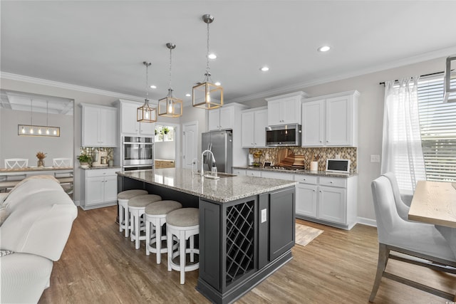264 Switchgrass Loop, Little River, SC 29566 - kitchen featuring appliances with stainless steel finishes, decorative backsplash, recessed lighting, a breakfast bar area, and a kitchen island with sink