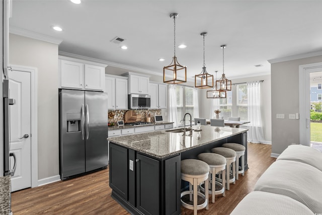 264 Switchgrass Loop, Little River, SC 29566 - kitchen with appliances with stainless steel finishes, ornamental molding, white cabinetry, a center island with sink, and dark wood-style floors