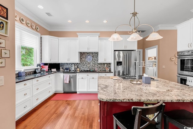 128 Knotty Pine Way, Murrells Inlet, SC 29576 - kitchen with appliances with stainless steel finishes, a breakfast bar, ornamental molding, light wood-type flooring, and decorative backsplash
