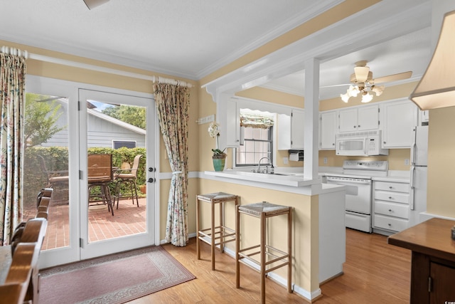 315 72nd Ave N Unit A, Myrtle Beach, SC 29572 - kitchen with white appliances, a peninsula, light wood-style floors, white cabinets, and light countertops