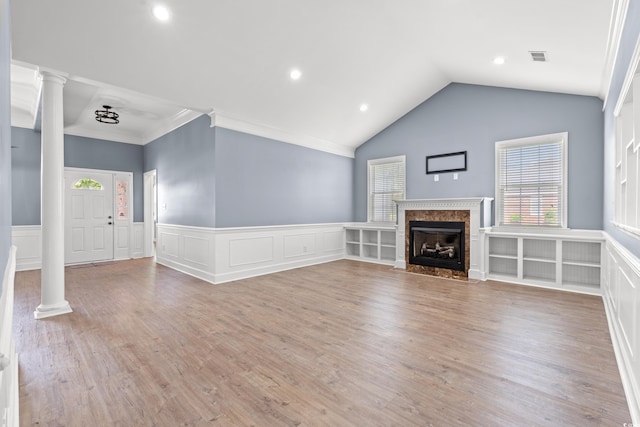307 Russ Rd, Loris, SC 29569 - unfurnished living room featuring ornate columns, wainscoting, light wood-type flooring, vaulted ceiling, and crown molding