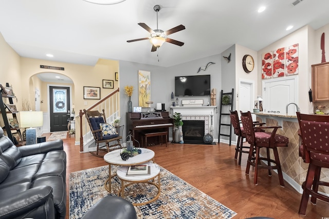 908 Ashbourn Ct, Murrells Inlet, SC 29576 - living area with a ceiling fan, arched walkways, stairs, wood finished floors, and a fireplace with flush hearth