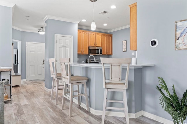 314 Black Oak Ln Unit 102, Murrells Inlet, SC 29576 - kitchen with stainless steel microwave, a breakfast bar, ornamental molding, light countertops, and recessed lighting