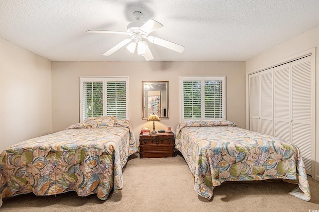 951 Plantation Dr Unit F1, Little River, SC 29566 - carpeted bedroom featuring multiple windows, a closet, a textured ceiling, and a ceiling fan