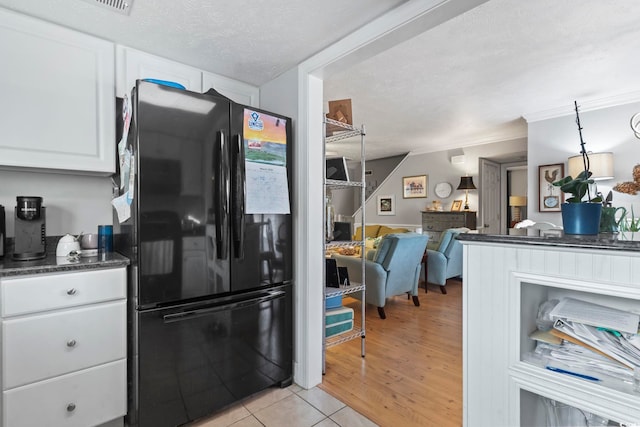 1710-C Edge Dr, North Myrtle Beach, SC 29582 - kitchen with freestanding refrigerator, dark countertops, white cabinetry, a textured ceiling, and open floor plan