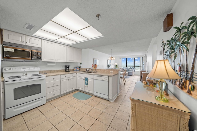 523 S Ocean Blvd Unit 305, North Myrtle Beach, SC 29582 - kitchen with white appliances, a peninsula, open floor plan, a textured ceiling, and light countertops