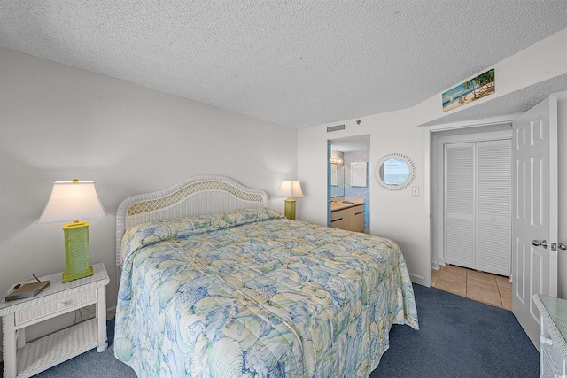 523 S Ocean Blvd Unit 305, North Myrtle Beach, SC 29582 - carpeted bedroom with a textured ceiling, connected bathroom, tile patterned flooring, and a closet