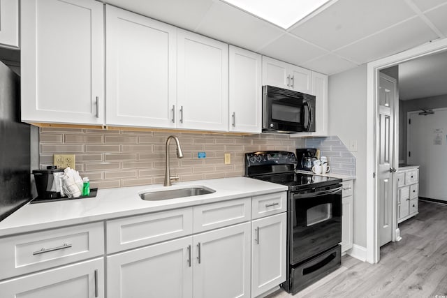 3000 N Ocean Blvd N Unit 1532, Myrtle Beach, SC 29577 - kitchen with black appliances, white cabinets, light wood-style floors, light countertops, and backsplash