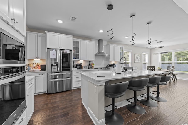 2212 Leeboard Ct, Myrtle Beach, SC 29579 - kitchen with stainless steel appliances, wall chimney range hood, dark wood-style flooring, glass insert cabinets, and a kitchen breakfast bar