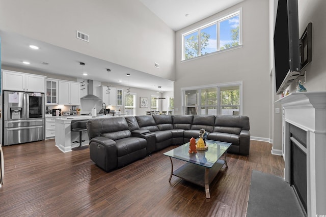 2212 Leeboard Ct, Myrtle Beach, SC 29579 - living room featuring a fireplace with flush hearth, plenty of natural light, dark wood finished floors, a towering ceiling, and recessed lighting