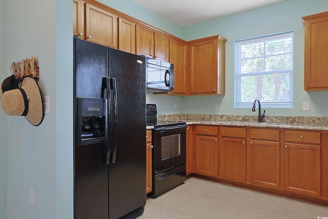 6253 Catalina Dr Unit 1711, North Myrtle Beach, SC 29582 - kitchen with black appliances, light stone counters, and brown cabinetry